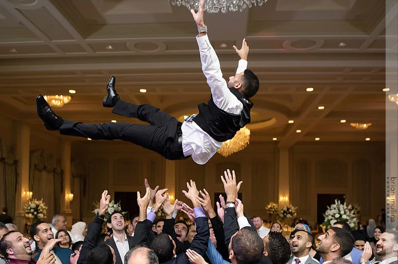 frontwedding01 - Stylus Weddings Wedding guests lift the groom into the air during a lively reception.