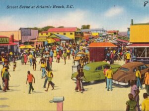 Historic street scene at Atlantic Beach, South Carolina, with crowds, businesses, and vintage cars during the resort’s mid-century peak.